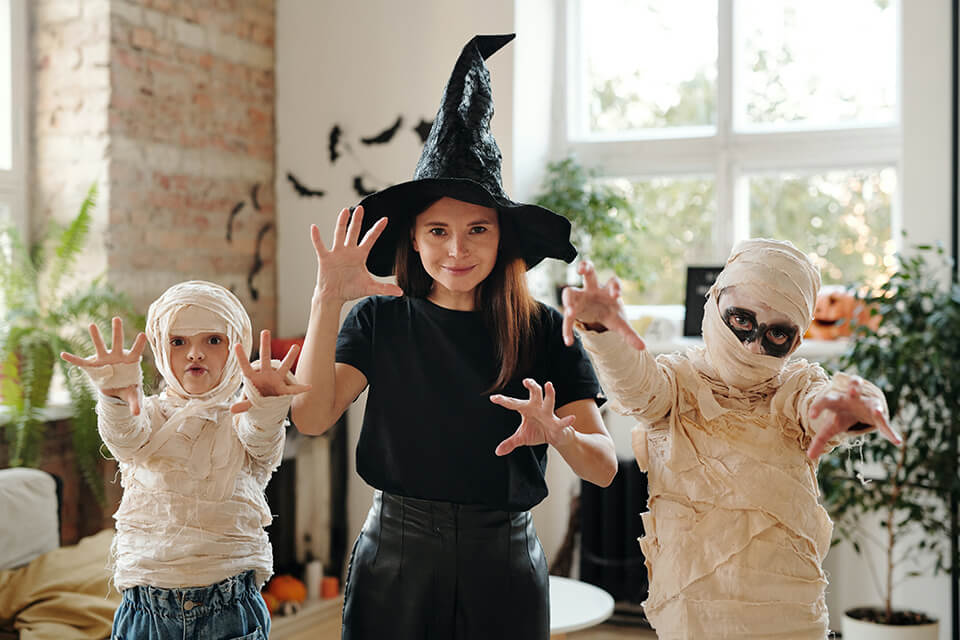 Frau mit Kindern in Halloween Kostümen