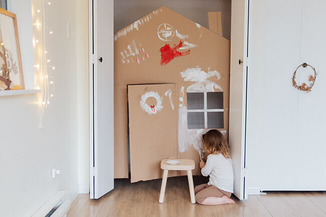 Kind gestaltet Hauskulisse aus Pappe